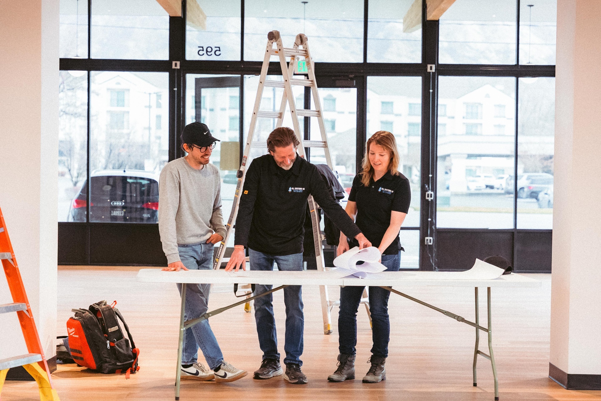 The All Systems Go construction team reviewing blueprints on site