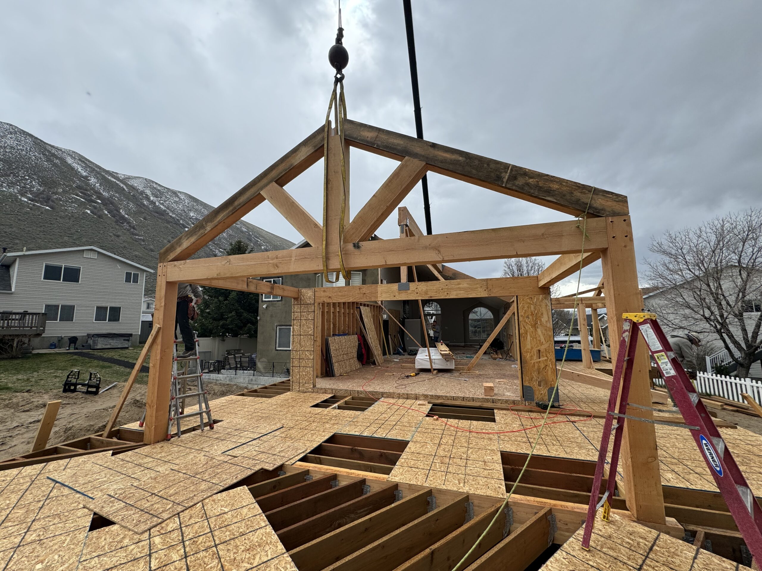 A house under construction featuring a wooden frame, with a sign reading "All Systems Go" prominently displayed.